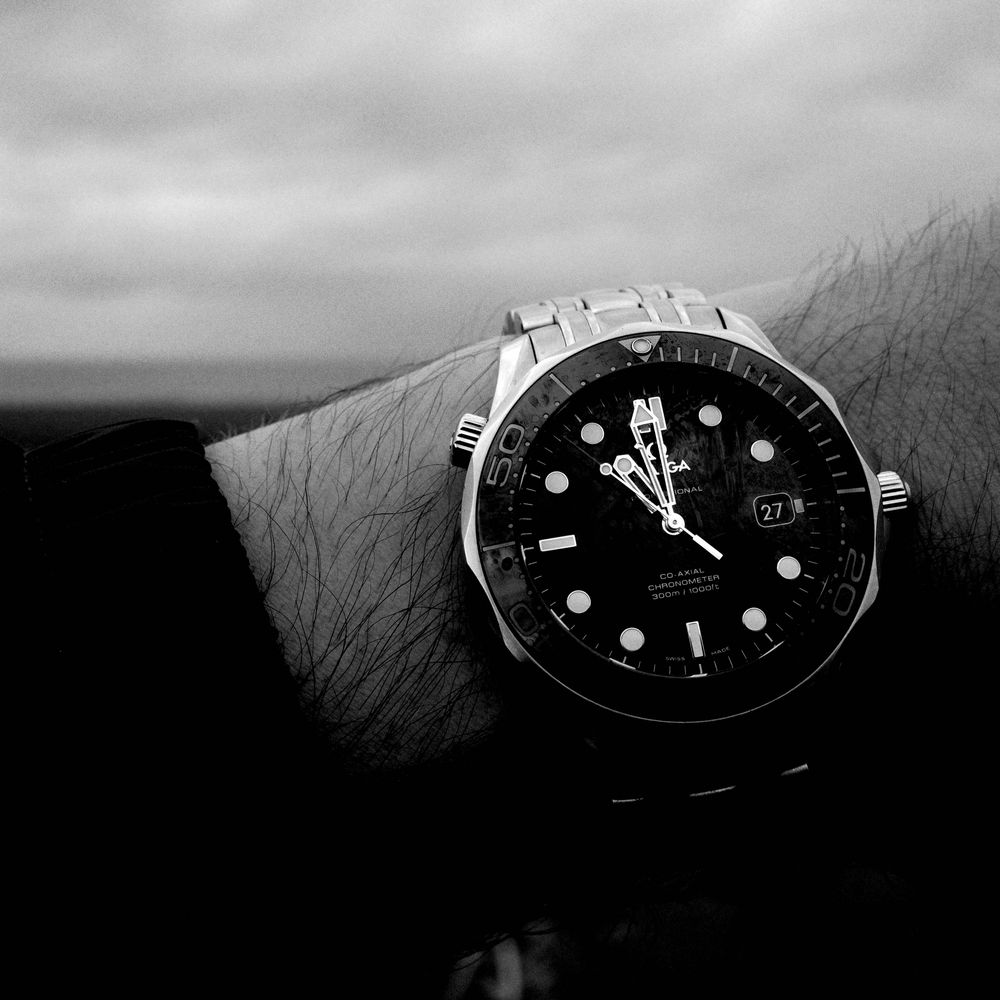 A watch on a wrist in front of the sea