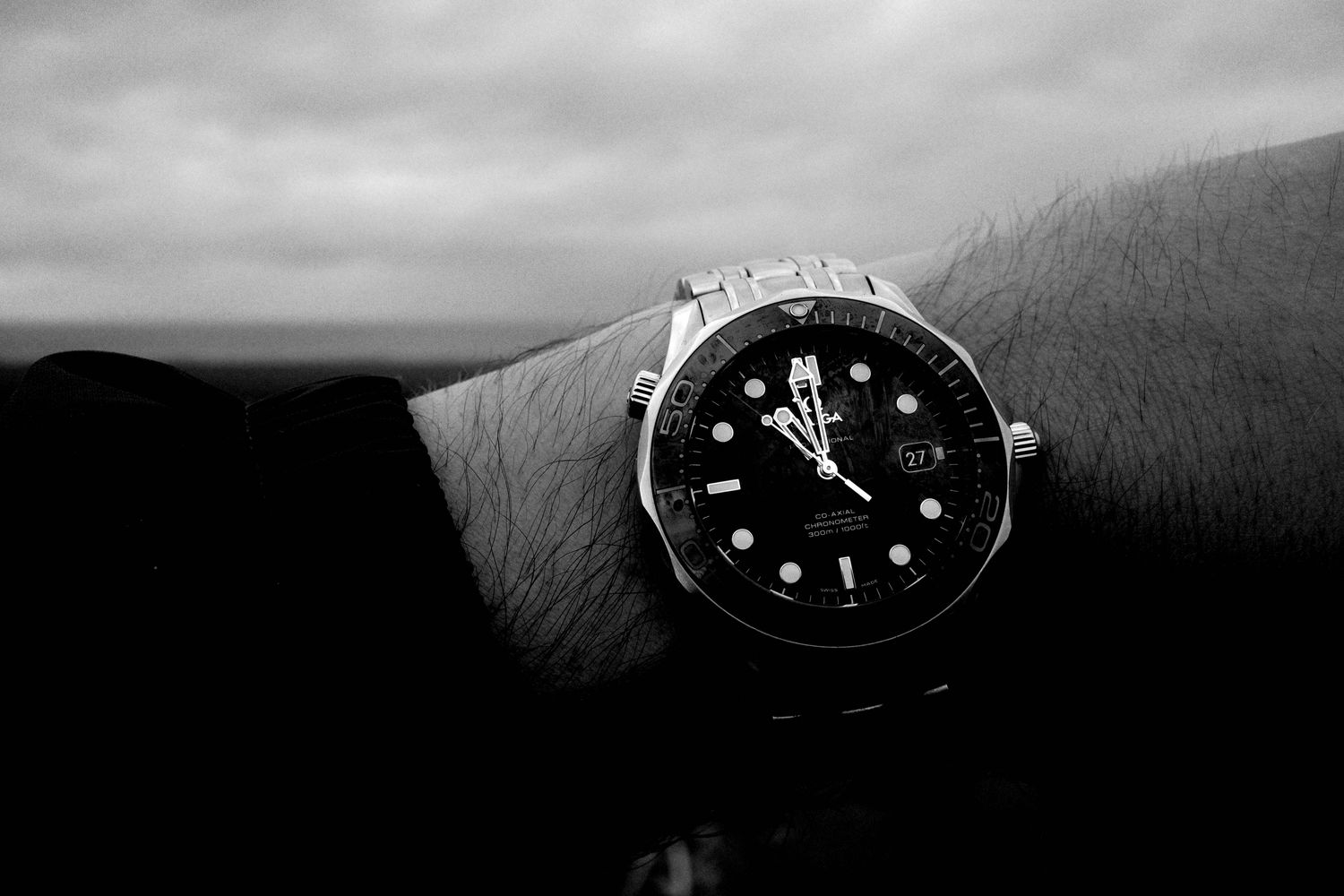 A watch on a wrist in front of the sea